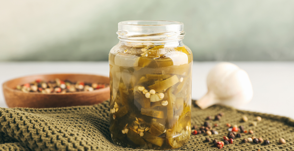 Sliced jalapeños in a jar submerged under brine for fermentation